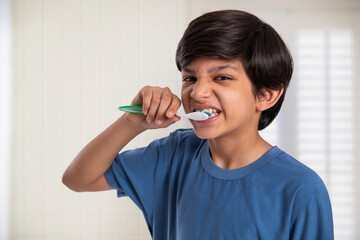 Close-up portrait of a boy brushing his teeth