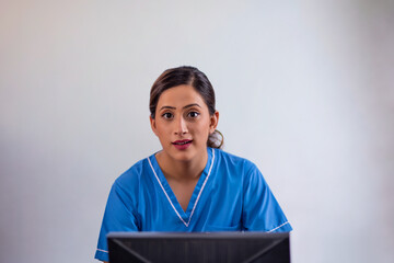 Portrait of a cheerful female nurse using computer