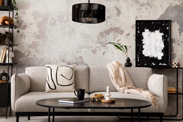 The stylish compostion at living room interior with design gray sofa, armchair, black coffee table, lamp and elegant personal accessories. Loft and industrial interior. Template. .