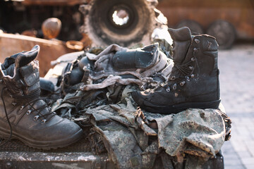 Remains of russian soldiers. Burned russian military uniform lying on destroyed russian armored...