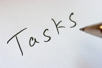 Close up image of handwritten word TASKS.