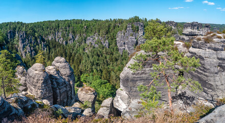 Panoramic over monumental Bastei sandstone pillars, rock formation and stacks surrounded by ancient forests at Kurort Rathen village in the national park Saxon Switzerland by Dresden, Saxony, Germany.