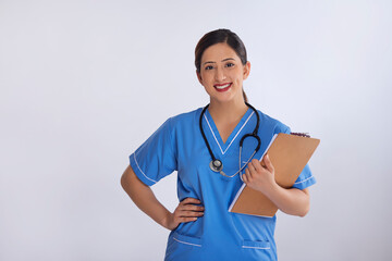 Portrait of a cheerful female nurse standing with clipboard in hand against white background