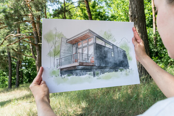 Contemporay house design hand drawn  sketch in architecht's hands.
