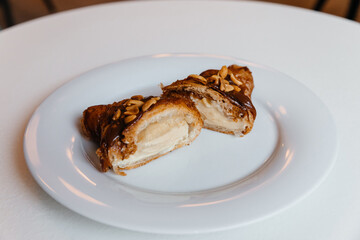 appetizing croissant with chocolate and peanuts on a plate