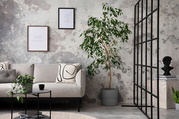 The stylish compostion at living room interior with design gray sofa, coffee table, plant, hanger,...
