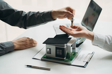 hand of young man customer signing contract for buying house with real estate broker in suit at estate agent office, investment, home loan contract, buying house, real estate and insurance concept