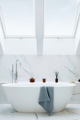 Stylish bathroom interior design with marble panels. Bathtub, towels and other personal bathroom...