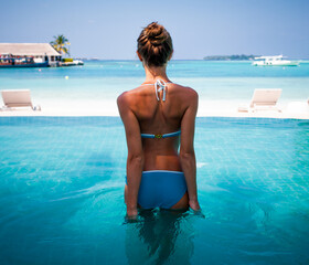 Young attractive blonde girl with perfect sport body in bikini on the tropical summer beach with pool © Vasily Makarov