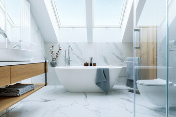 Stylish bathroom interior design with marble panels. Bathtub, towels and other personal bathroom...