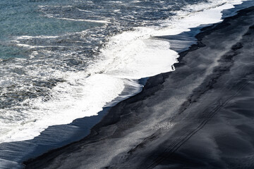 ocean waves meet black beach - 514413552