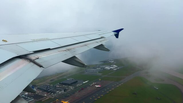 Passenger point of view of jet  commercial Airbus A320 airplane wing at takeoff from Copenhagen airport on cloudy day