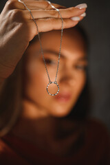 Attractive brunette with a cold pendant on chains around her neck. Precious gift. - 514416581