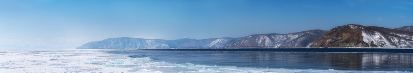 Winter landscape panorama with mountains and Lake Baikal in Siberia on sunny day. Natural background.