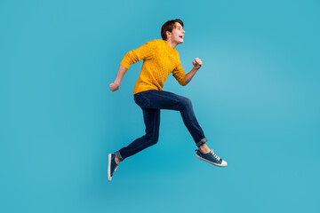Fototapeta na wymiar Profile side photo of guy full body run high hurry advertising on blue wall background studio shot
