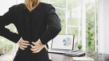 Young business woman at the office with terrible back pain