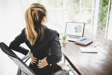 Young business woman at the office with terrible back pain