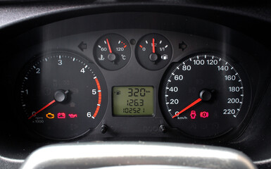 A close-up of a car panel with a speedometer indicating, oil and gasoline levels. Car panel,...