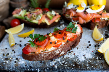 Salted salmon open sandwich with tomatoes, cream cheese, cucumber, parsley and pepper. Healthy seafood