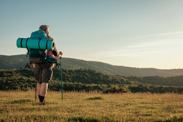 Man hiking on mountain with the help of hiking poles