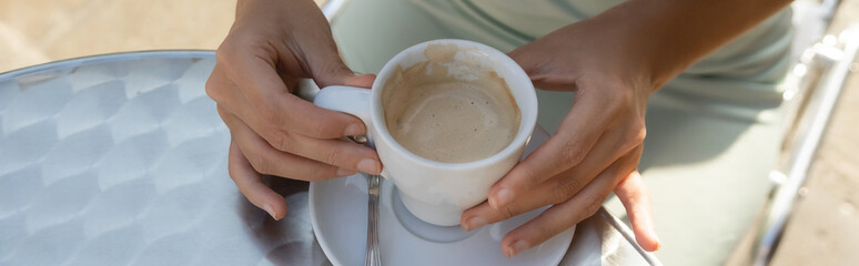 partial view of woman near coffee cup on table in venetian cafe, banner.