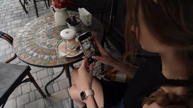 a girl takes pictures of coffee and then looks at the result.