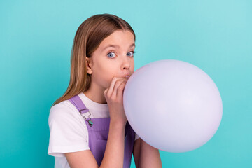 Portrait of adorable sweet girl blow inflate air balloon prepare decoration isolated on turquoise color background