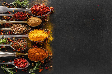 Various spices a vintage spoons on stone table. Colorful Herbal and Spices Oriental marketplace.Top view . Cafe concept. Delicious food delivery.
