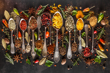 Various spices a vintage spoons on stone table. Colorful Herbal and Spices Oriental marketplace.Top view . Cafe concept. Delicious food delivery.