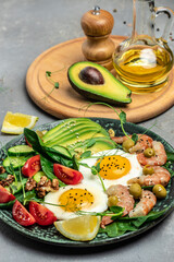 Ketogenic breakfast. Keto low carb shrimps, prawns, quail eggs, fresh salad, tomatoes, cucumbers and avocado on a light background. keto diet. Top view