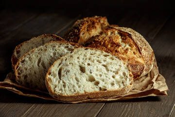 Bread, traditional sourdough bread cut into slices on a rustic wooden background. Concept of traditional leavened bread baking methods. Healthy food.