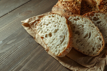 Bread, traditional sourdough bread cut into slices on a rustic wooden background. Concept of traditional leavened bread baking methods. Healthy food.