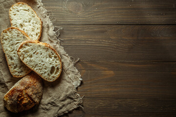 Bread, traditional sourdough bread cut into slices on a rustic wooden background. Concept of traditional leavened bread baking methods. Healthy food.
