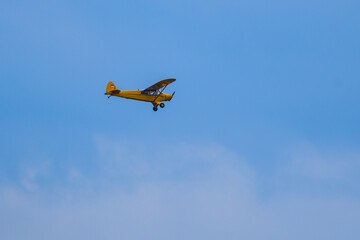 Fototapeta na wymiar Yellow airplane flying in blue sky