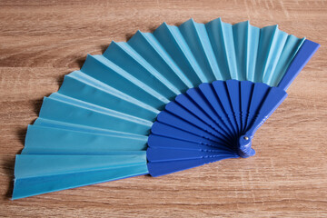 A blue fan from Spain on wooden background