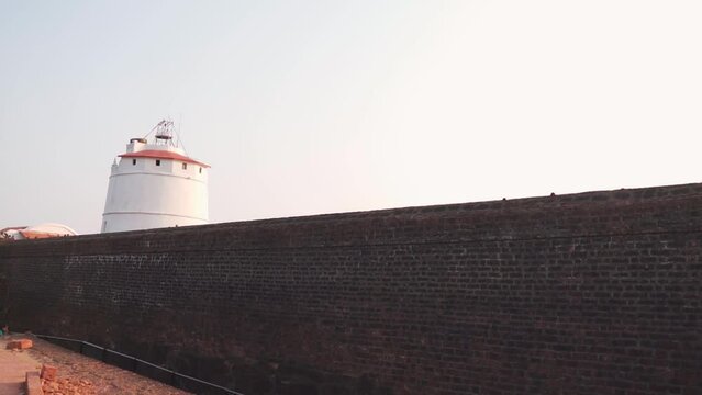 Wide angle shot of ancient lighthouse and fort wall of the Aguada Fort at Goa in India. Ancient fort of Goa. Wide angle shot of fort with lighthouse inside of it, made by the Portuguese. 