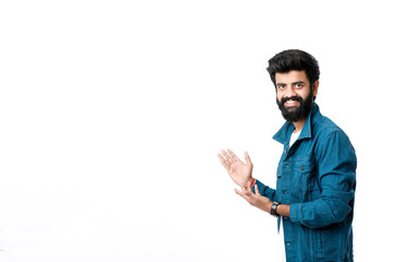 Young indian man showing direction with hand on white background.