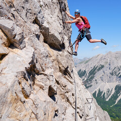Fototapeta premium Active woman on via ferrata Nordkette Innsbruck, Austria. Rock details, adventure, activity, tourism, klettersteig.