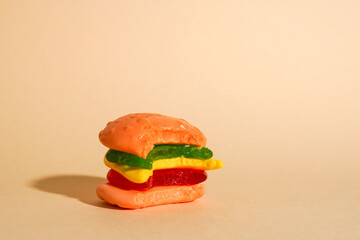 candy bitten off hamburger on yellow background with copy space