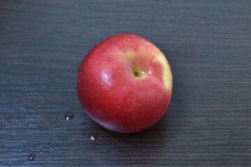 Ripe, red apple lies on the board