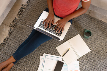 High angle view of young african american woman using laptop while freelancing at home, copy space