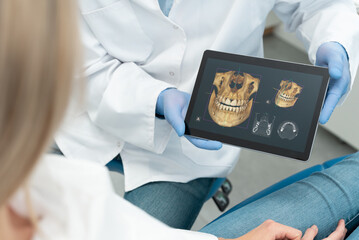 Dentist showing teeth x-ray on tablet screen