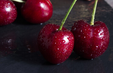 Red juicy cherry on a dark stone stand close-up