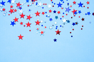 Patriotic USA background with silver, red and blue stars shape sparkles on light blue. Festive background with copy space. Independence Day, Memorial Day and Flag Day celebration concept