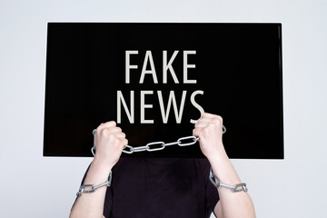 Man with lcd display TV head and chain on hands on white background. Fake news, control and...