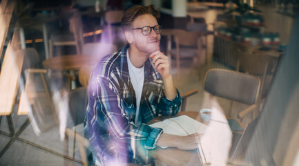 Young caucasian guy working or studying at table