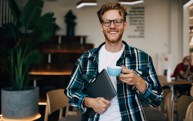 Young guy drinking tea or coffee in office space