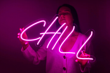 Beautiful girl with neon signs. Pink neon sign chill. Trendy style. Neon sign. Custom neon. Home decor.