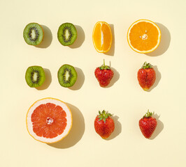 Food pattern made with fresh fruit slices on the yellow . background. Fruit healthy flat lay composition.