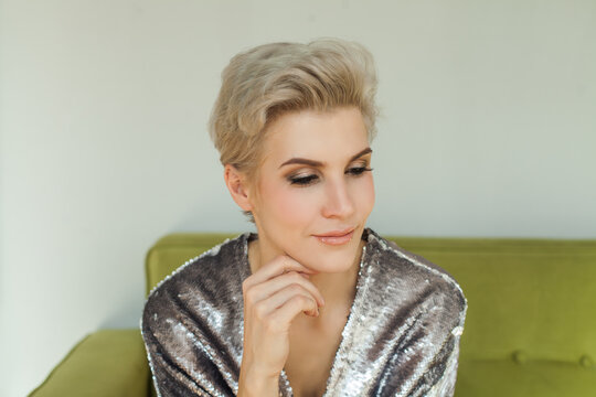 Close up image of cute blonde woman with short pixie hairstyle at home